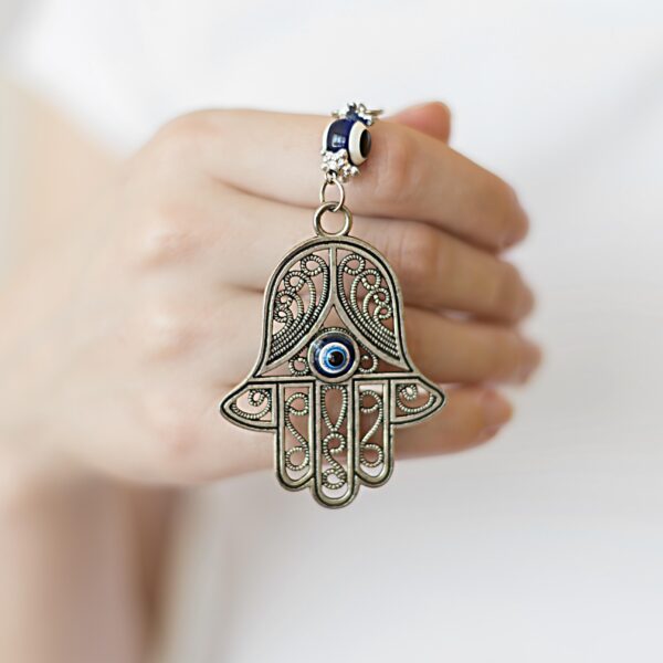 front-view-person-holding-hamsa-pendant